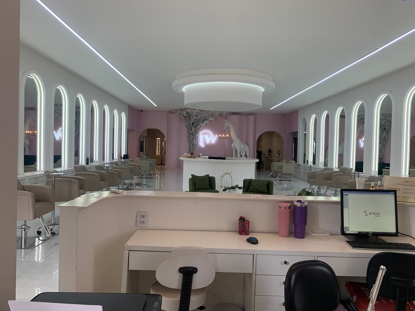 Salão principal do Tati Welter Authentic Spa: arcos espelhados iluminados, paredes rosa e lustre central