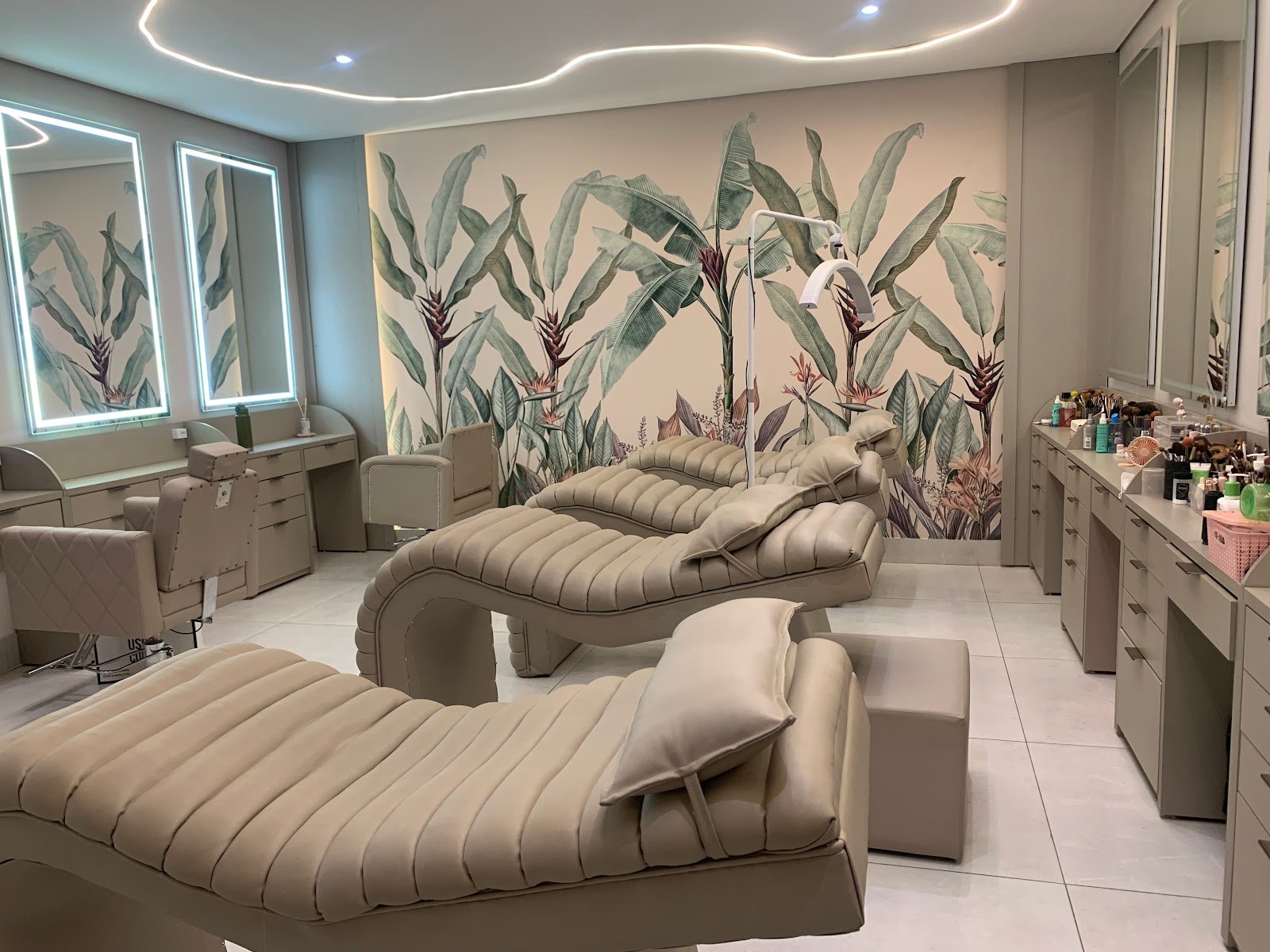 Sala de tratamentos do spa com macas, espelhos iluminados e bancadas de maquiagem
